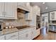 Kitchen with white cabinets, tile backsplash, stainless steel appliances, and a wine fridge at 1830 Hadfield Blvd, Roswell, GA 30075