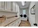 Laundry room featuring a washer and dryer, granite countertops, and storage cabinets at 1830 Hadfield Blvd, Roswell, GA 30075