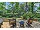 Outdoor patio features stone flooring and wrought iron patio furniture surrounded by lush greenery at 1830 Hadfield Blvd, Roswell, GA 30075