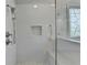 Walk-in shower is tiled with a built-in seat, dual showerheads, and decorative niche at 1830 Hadfield Blvd, Roswell, GA 30075