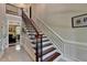 Elegant staircase with wood and iron railing, complemented by wainscoting, adds architectural detail at 1830 Hadfield Blvd, Roswell, GA 30075