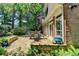 Relaxing stone patio with dining set, surrounded by landscaped gardens, providing an ideal outdoor living space at 1830 Hadfield Blvd, Roswell, GA 30075