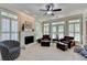 Bright sunroom with fireplace, two leather chairs, ceiling fan and exterior light at 1830 Hadfield Blvd, Roswell, GA 30075