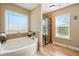 Bright bathroom with a soaking tub, decorative tile accents, a large window, and glass-door shower at 245 Tapestry Dr, Mcdonough, GA 30252