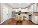 Bright kitchen features granite countertops, stainless steel appliances and hardwood flooring at 245 Tapestry Dr, Mcdonough, GA 30252