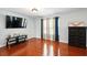 Open living room featuring hardwood floors, a large TV, and several windows that provide ample natural light at 245 Tapestry Dr, Mcdonough, GA 30252