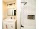 Modern bathroom features subway tile shower with black fixtures and vanity with framed mirror and modern lighting at 2751 Colonial Dr, College Park, GA 30337