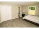 A cozy bedroom featuring modern flooring, a double closet, and an ensuite bathroom at 2751 Colonial Dr, College Park, GA 30337