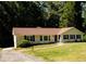 Well-maintained single-story home with blue shutters, a manicured lawn, and mature trees at 2751 Colonial Dr, College Park, GA 30337