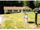 Charming single-story home with a well-maintained lawn, mature trees, blue shutters, and a for sale sign at 2751 Colonial Dr, College Park, GA 30337