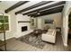 Cozy living room boasts exposed beams, white brick fireplace, modern ceiling fan, and stylish, neutral-toned furniture at 2751 Colonial Dr, College Park, GA 30337