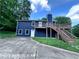 Two-story house with blue siding, a deck, stairs, and a concrete driveway at 4464 Cary Dr, Snellville, GA 30039
