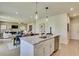 Open kitchen with granite countertops, stainless steel appliances and an island, flowing into the dining and living area at 516 Altamaha Ct, Locust Grove, GA 30248
