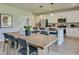 Modern kitchen featuring an island with seating, stainless steel appliances, and an adjacent dining area at 516 Altamaha Ct, Locust Grove, GA 30248