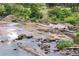 Scenic rocky river with flowing water surrounded by lush greenery at 516 Altamaha Ct, Locust Grove, GA 30248
