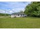 Spacious backyard featuring a well-maintained lawn and mature trees providing ample shade and privacy at 405 Emory St, Oxford, GA 30054