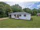 Charming single-story home with a well-maintained lawn and mature trees in a serene setting at 405 Emory St, Oxford, GA 30054