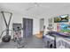 Light and airy home gym includes a workout bike, rower, and mounted television at 405 Emory St, Oxford, GA 30054