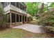 Backyard with a stone patio, screened porch, and lush landscaping, creating a serene outdoor retreat at 5065 Hickory Hills Dr, Woodstock, GA 30188