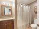 Well-lit bathroom featuring a vanity with a wood cabinet, mirror, and a shower with a striped curtain at 5065 Hickory Hills Dr, Woodstock, GA 30188