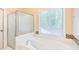 Bathroom featuring soaking tub and shower with mosaic tile backsplash at 5065 Hickory Hills Dr, Woodstock, GA 30188