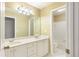 Bathroom with double sink vanity, large mirror and well lit lighting at 5065 Hickory Hills Dr, Woodstock, GA 30188
