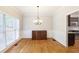 Formal dining room with hardwood floors, decorative chandelier, wainscoting, and a large window overlooking the yard at 5065 Hickory Hills Dr, Woodstock, GA 30188