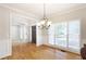 Formal dining room showcasing hardwood floors, white trim, chandelier, and natural light at 5065 Hickory Hills Dr, Woodstock, GA 30188