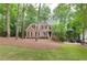 Traditional two-story brick home with manicured lawn, mature trees, and driveway at 5065 Hickory Hills Dr, Woodstock, GA 30188
