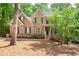 Charming two-story red brick home with manicured lawn and mature trees in a well-maintained neighborhood at 5065 Hickory Hills Dr, Woodstock, GA 30188
