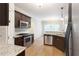 Modern kitchen featuring stainless steel appliances, granite countertops, dark cabinets, and hardwood floors at 5065 Hickory Hills Dr, Woodstock, GA 30188