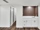 Basement features wood floors and wet bar with white cabinets and brown wood paneling at 529 Greystone Trl, Marietta, GA 30068