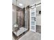 Modern shower features glass doors, rainfall showerhead, and stylish gray tiling at 529 Greystone Trl, Marietta, GA 30068