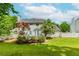 Well-maintained backyard featuring a wooden deck, mature trees, and a white picket fence at 855 Madison Chase Way, Lawrenceville, GA 30045