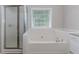 Bathroom with a glass-enclosed shower and a large soaking tub at 855 Madison Chase Way, Lawrenceville, GA 30045