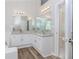 Bright bathroom with double vanity, granite countertop, and wood-look flooring at 855 Madison Chase Way, Lawrenceville, GA 30045
