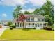 Beautiful home showcasing a lush green lawn and a welcoming front porch, complete with classic shutters at 855 Madison Chase Way, Lawrenceville, GA 30045