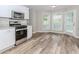 Stylish kitchen features white cabinets, stainless steel appliances, and wood-look flooring at 855 Madison Chase Way, Lawrenceville, GA 30045