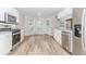 Modern eat-in kitchen with stainless appliances, white cabinets, and wood-look flooring at 855 Madison Chase Way, Lawrenceville, GA 30045
