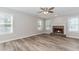 Inviting living room with brick fireplace, ample natural light, and wood-look flooring at 855 Madison Chase Way, Lawrenceville, GA 30045