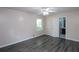 Bedroom with gray floors, light pink walls, a window, a ceiling fan, and an open door to a bathroom at 175 Brookhaven Dr, Marietta, GA 30066