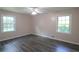 A spacious bedroom with gray floors, light pink walls, two large windows, and a ceiling fan at 175 Brookhaven Dr, Marietta, GA 30066