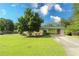 Spacious front yard with a lush green lawn, mature trees, and a covered carport at 175 Brookhaven Dr, Marietta, GA 30066