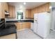 Kitchen with wood cabinets, black countertops, a stainless steel sink, and a white refrigerator at 175 Brookhaven Dr, Marietta, GA 30066