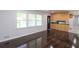 Living room with hardwood floors, gray walls, three windows, and an open entryway into a kitchen at 175 Brookhaven Dr, Marietta, GA 30066