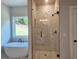 Bright bathroom featuring soaking tub and glass enclosed shower with marble tile at 222 Silvercrest Dr, Acworth, GA 30101