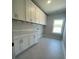 The spacious laundry room features white cabinets for ample storage and a window for natural light at 222 Silvercrest Dr, Acworth, GA 30101