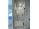 Close up of a modern glass enclosed shower with matte black hardware and bright white marble-look tile at 222 Silvercrest Dr, Acworth, GA 30101