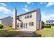 View of backyard, chimney, and patio with windows and a partial view of adjacent home at 310 Hammersmith Dr, Suwanee, GA 30024