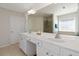 Primary bathroom boasts a double sink vanity and bright vanity lighting at 310 Hammersmith Dr, Suwanee, GA 30024